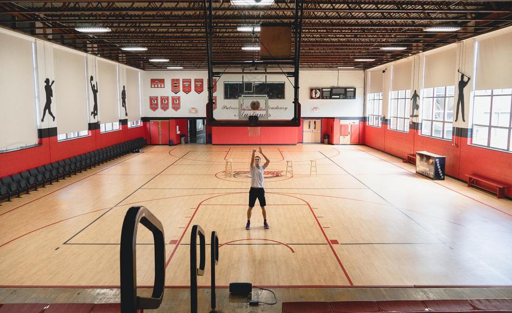student shooting free throws alone in gym